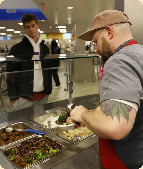 Server plating food at a busy station