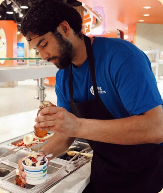 Staff member finishing a dish at the line